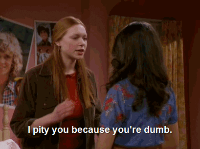 TV gif. Laura Prepon as Donna on That '70s Show speaks sternly to Mila Kunis as Jackie, "I pity you because you're dumb," which appears as text.