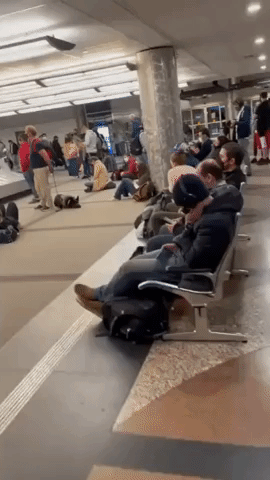 Passengers Wait at Baggage Claim Amid Flight Disruptions at Denver Airport