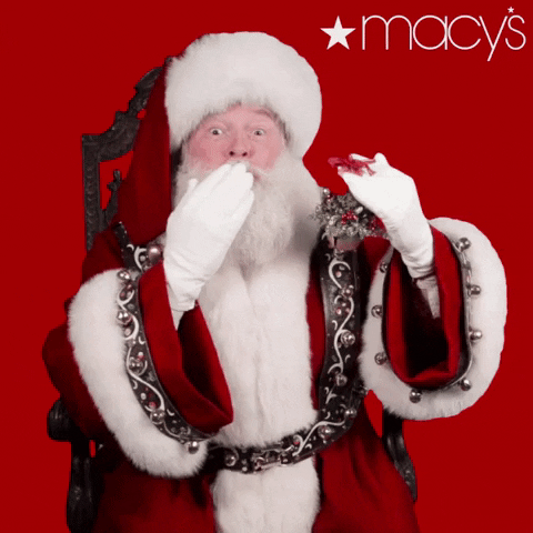 Ad gif. An ad for Macy's. Santa is sitting and blows us a jolly kiss while holding mistletoe. 