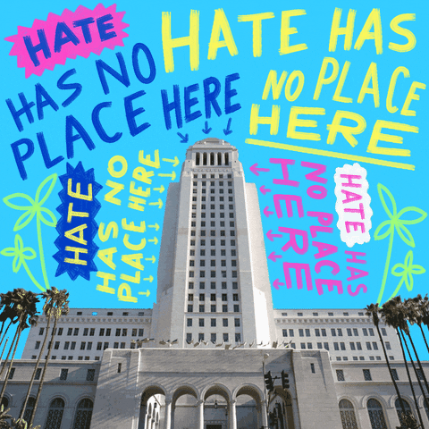 Digital art gif. Photo of Los Angeles City Hall on a cyan background, graffitied with bright text and flashing arrows. Text, "Hate has no place here, hate has no place here, hate has no place here."