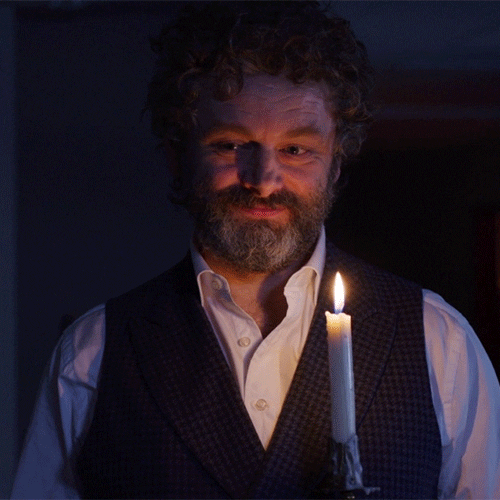 Actor Michael Sheen blowing out a lit candle