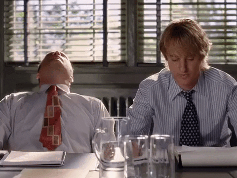 Movie gif. Vince Vaughn as Jeremy and Owen Wilson as John sitting at a table in business attire, looking exasperated as Jeremy sits up and rubs his head and John fiddles with a pen.