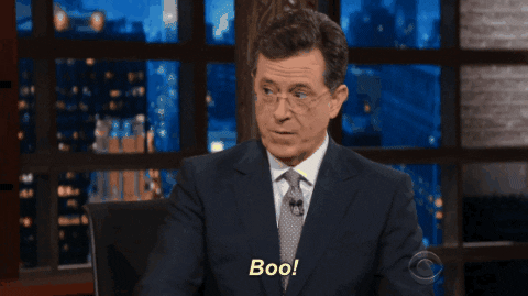 TV gif. Stephen Colbert leans forward with a startling "Boo!"