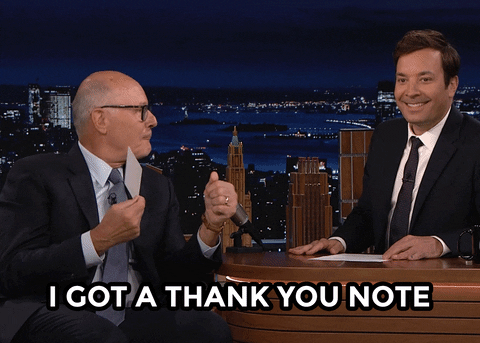 A man is excitedly showing a note while shaking another man's hand, with the words "I GOT A THANK YOU NOTE" written below.