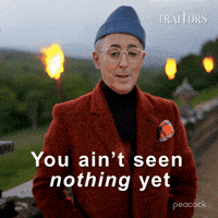 Sponsored gif. Alan Cumming as host of in The Traitors wearing a fuzzy orange suit jacket and blue beanie says, “You ain’t seen nothing yet.” Text also reads, “You ain’t seen nothing yet.” 