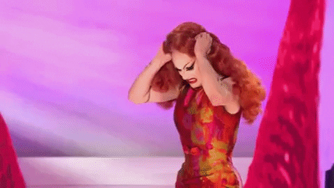 Sasha Velour performing in RuPaul’s Drag Race slowly lifts and shakes her curly red wig as hidden red rose petals cascade down her bald head, lip singing the lyrics, “I get so emotional baby,” like she’s screaming through her frustration.