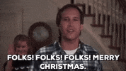Movie gif. Chevy Chase as Clark in National Lampoon’s Christmas Vacation looks upon his family and friends with a proud grin and says, “Folks! Folks! Merry Christmas.” Beverly D’Angelo as Ellen Griswold stands behind him waving, opening and closing her hand, and smiles so wide that she crinkles her nose.