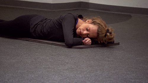 Reality TV gif. Dina Manzo from Real Housewives of New Jersey lying down on her belly on a mat on the floor of a gym