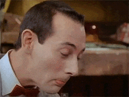 TV gif. Paul Reubens as Pee-wee Herman turns and looks at us with surprise, eyes wide and mouth open.