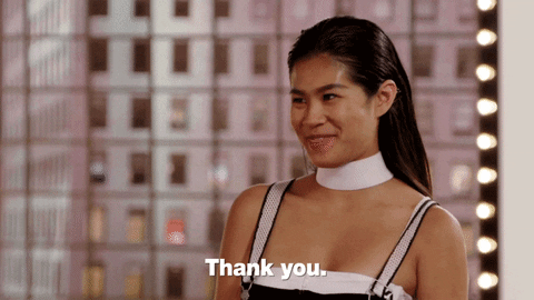 Reality TV gif. Contestant on America's Next Top Model smiles and covers her mouth timidly as she says, "Thank you," which appears as text.