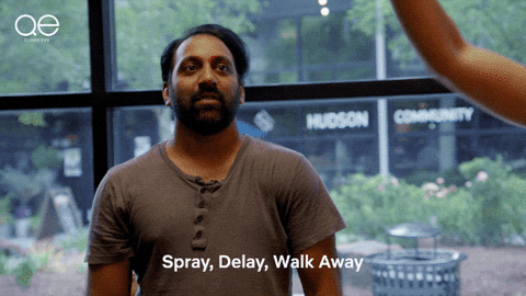 Man proudly puffs out his chest as Jonathan Van Ness spritzes cologne in the air, sweeping his arm out dramatically. The man takes a beat then does a catwalk-style strut through the spray like he’s oozing confidence. Caption, “Spray, Delay, Walk Away.” 