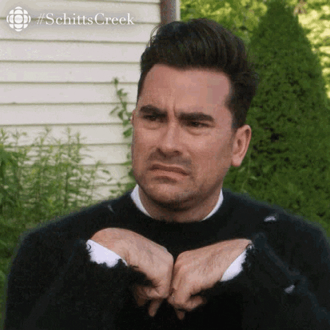 Schitt's Creek gif. David curls his hands in front of his chest and grimaces in disgust.