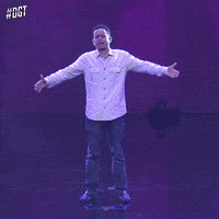 Reality TV gif. Man prays on stage on Dominicana’s Got talent, opening and raising his arms to the sky.