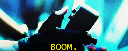 Movie gif. Rihanna as Cora in Battleship appears focused and says "boom" while she presses a button on a handheld controller.