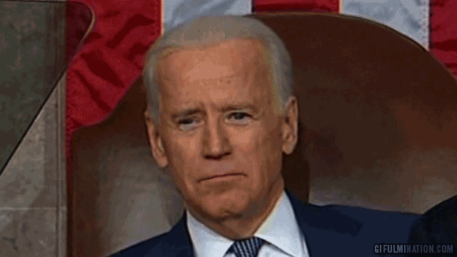Political gif. Joe Biden sits in the senate chamber and looks down in front of him. His face brightens, his eyebrows rise up high, and his smile widens super big.
