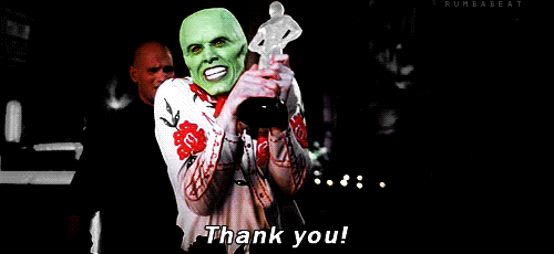 Movie gif. Jim Carrey dressed in a floral shirt with a green face as The Mask, holding onto what looks like an Oscar award, expressing over-the-top gratitude, shaking his head as he says "thank you!"