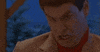 Movie gif. Jim Carey as Lloyd in "Dumb and Dumber" makes an absurd retching facial expression and gesture, bucking his neck forward and curling his lips over his teeth and then clenching his jaw.