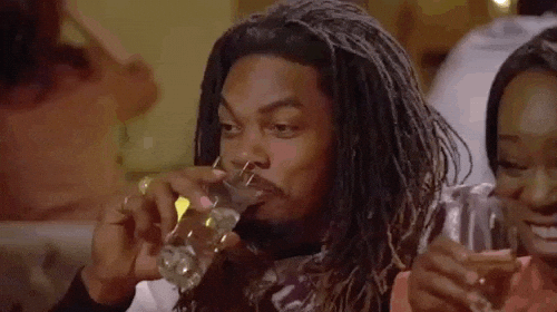 Reality TV gif. A man on Basketball wives takes a sip of his drink and has a nervous smile on his face. 