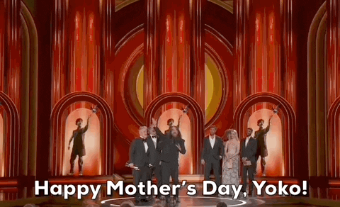Oscars 2024 GIF. Sean Lennon, son of Yoko Ono and John Lennon, pumps his fist in the air and shouts, "Happy Mother's Day, Yoko!" as he celebrates his win in conjuction to celebrating his mother on United Kingdom's Mother's Day. 