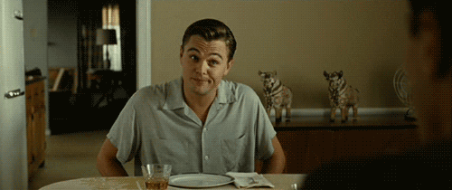 Movie gif. Leonardo DiCaprio as Frank Wheeler in Revolutionary Road sits at a dining room table across from someone. He shrugs his shoulders and lifts his eyebrows with a smirk on his face.