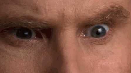 Movie gif. Close-up on the eyes of Will Ferrell as Ron Burgundy in Anchorman as he glares angrily, his eyes reflecting fiery explosions. He then grabs a woman by her shoulders, swings her around and throws her over a desk while others in the newsroom watch.