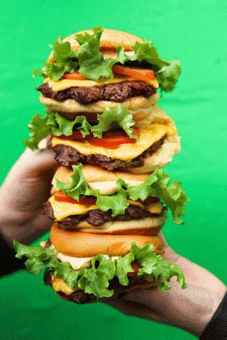 Ad gif. A stack of four Shake Shack cheeseburgers held up by two hands appears in front of alternating red, green, and yellow backgrounds.