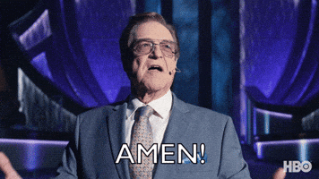 TV gif. Actor John Goodman as Dr. Eli in The Righteous Gemstones wears tinted Aviator glasses and a nice suit, with an over ear microphone next to his mouth. He raises his arms up to the heavens, looks up, and shouts, “Amen!”