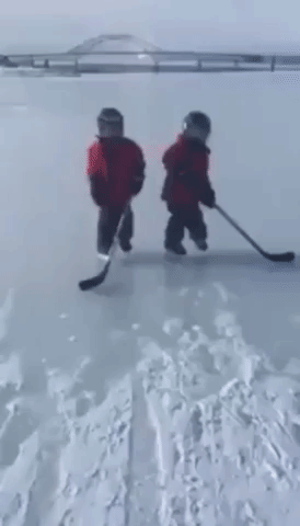 Young Twins Skate Fearlessly on Frozen River