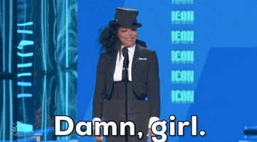 Celebrity gif. Janet Jackson at the 2022 Billboard Music Awards on stage squints and smiles as she says "damn, girl," which appears as text.
