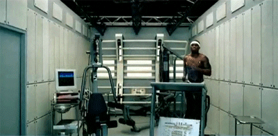 Music video gif. In his "In da Club" video, 50 cent runs on a treadmill in a confined space that looks like a gym combined with a hospital room and a garage. A heart monitor machine rests to the right.