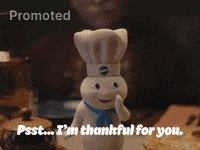 Sponsored gif. Pillsbury Doughboy leans forward and whispers into his hands, "Pssst...I'm thankful for you."