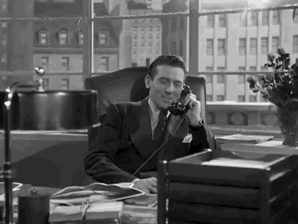 Movie gif. A man in Christmas in Connecticut sits in a handsome leather chair in an office, cigarette in hand and corded phone to his heart. He smiles as he says into the phone, "May I wish you a Merry Christmas?"