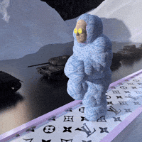 Video art gif. Person wearing a puffy sky-blue body suit and smiley-face sunglasses runs on a treadmill track decorated with the Louis Vuitton logo pattern. Behind him, a line of army tanks roll past snow-covered mountains.