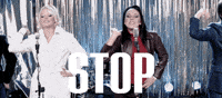 Music video gif. The Spice Girls from the video for Stop, singing and gesturing, stretching out, palms faced out to us. Text, "Stop!"