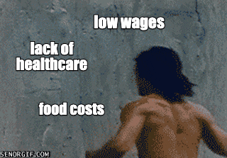 Video gif. Shirtless man punches through a massive concrete wall labeled “Low wages, lack of healthcare, food costs. As the wall crumbles, we see through to the other side, labeled “The end of global poverty.”