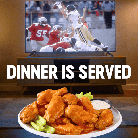 Sponsored gif. Hand drizzles Frank’s RedHot sauce over a plate of chicken wings. Beyond the plate, a TV shows a football game. Text reads, “Dinner is served.”