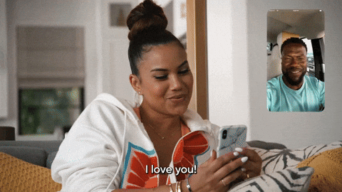 Reality TV gif. Eniko Hart on Real Husbands of Hollywood smiles and kisses her phone as she FaceTimes with Kevin Hart. He smiles and says, "I love you" from a screen in the upper right corner.
