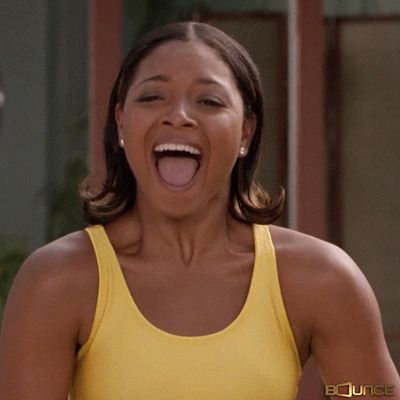 TV gif. A woman with curled shoulder-length hair wearing a yellow top bends forward, cracking up hysterically.
