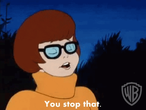 Cartoon gif. Velma from Scooby Doo looks sternly through her thick black glasses. Text, "You stop that."