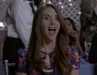 TV gif. Allison Brie as Annie on Community. She's ecstatic and her eyes and mouth go wide as she eagerly leans forward and says, "Yeah!"