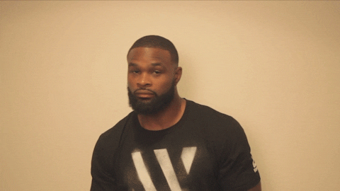 Celebrity gif. Tyron Woodley closes his eyes, lifting his eyebrows up, and smirking a bit. He leans forwards and opens his eyes to look straight at us, squinting his eyes a bit.
