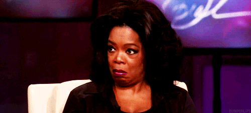TV gif. Oprah Winfrey frowns and gives a side-eye, as if to say, “oops.”
