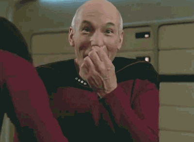 TV gif. Patrick Stewart as Picard in Star Trek shrinks and looks amused and embarrassed, looking left and right and then at us, smiling.