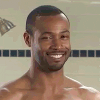 Ad gif. From an Old Spice ad: naked in the shower, Isaiah Mustafa nods his head and smiles, then raises his eyebrows flirtatiously.
