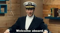 TV gif. Scott Aukerman on Comedy Bang Bang looks at us while wearing a boat captain’s hat. He waves his hand up and smirks as he says, “Welcome aboard.”