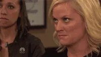 Parks and Recreation gif. Amy Poehler as Leslie purses her lips as her eyes dart around, in a seething rage.