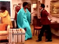 TV gif. Isabel Sanford as Louise and Sherman Hemsley as George in The Jefferson. The two are dressed in formal wear and begin dancing with one another and bumping booties as they jive to the music.