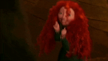 Disney gif. Merida hops excitedly, holding up her fists and smiling as her red curly hair bounces.