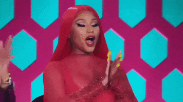 Reality TV gif. Nicki Minaj as a judge in RuPaul's Drag Race. She's impressed with what she's seen and claps her hands while whooping.