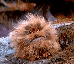 Movie gif. Fizzgig, a puppet creature from the Dark Crystal stomps its feet and opens its big mouth wide like it's screaming at the sky. 